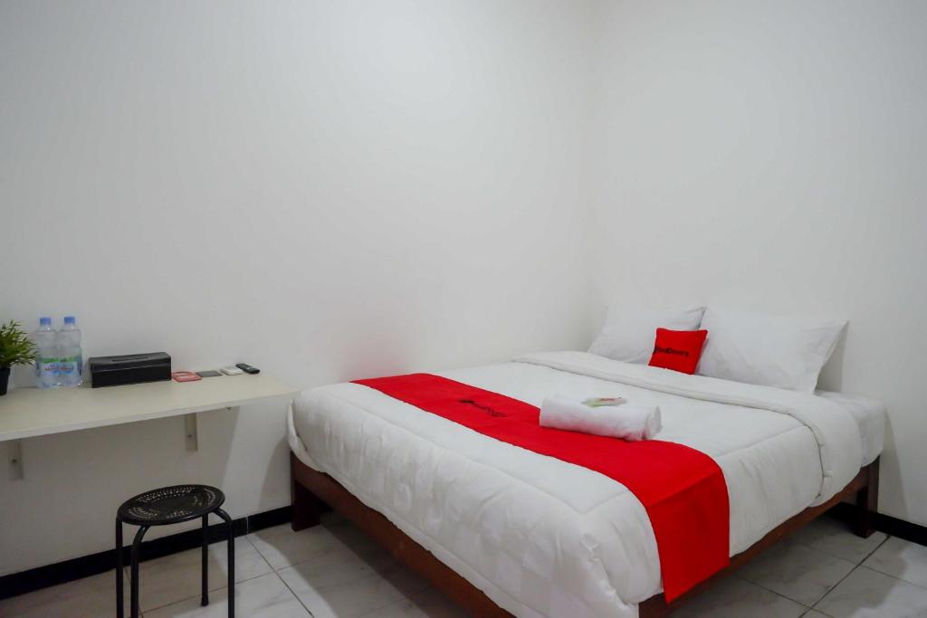 JatingalehRedDoorz near GOR Jatidiri Semarang的一间卧室配有一张带红白毯子的床