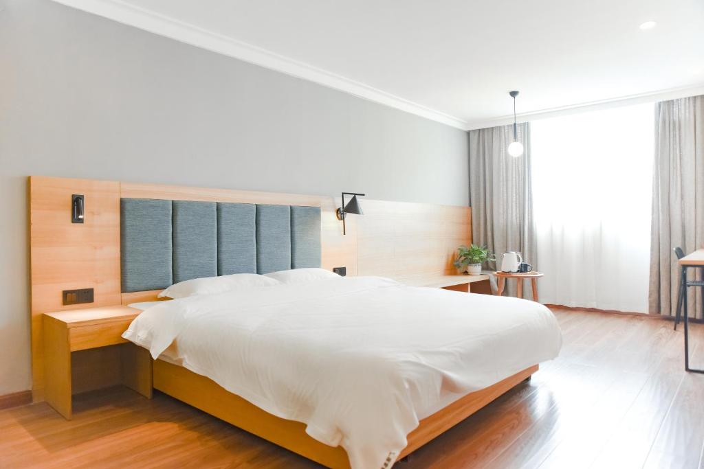 桂林桂林广湖客栈的卧室设有一张白色大床和大窗户
