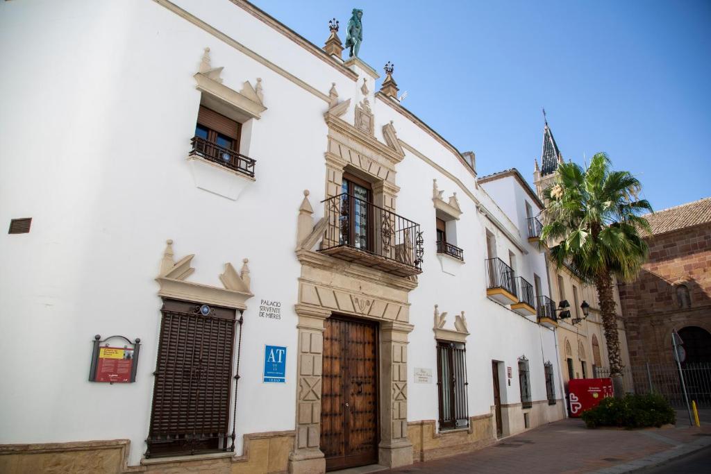 安度亚尔Palacio Sirvente Mieres - PARKING GRATUITO的街道上带有木门的白色建筑