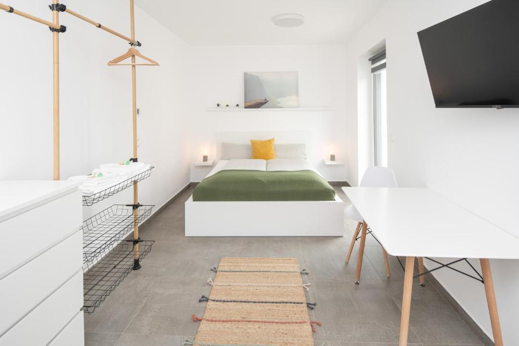 沃尔姆斯Nibelungen Apartments的白色卧室配有床和书桌