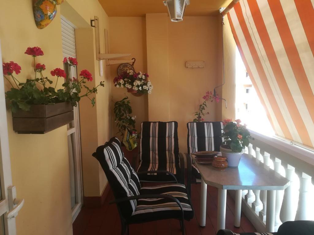马拉加Como en casa的一间设有两把椅子、一张桌子和一个窗户的房间