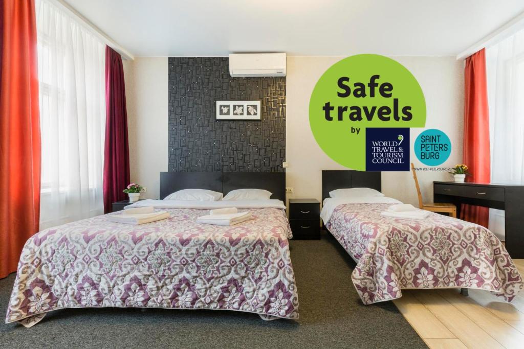 圣彼得堡琥珀酒店的酒店客房设有两张床,并标有安全旅行标志