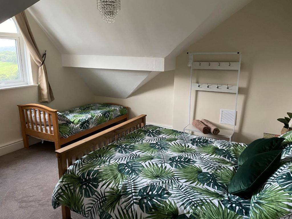 马特洛克Danbury Lodge Penthouse的一间卧室配有一张带绿色和白色棉被的床