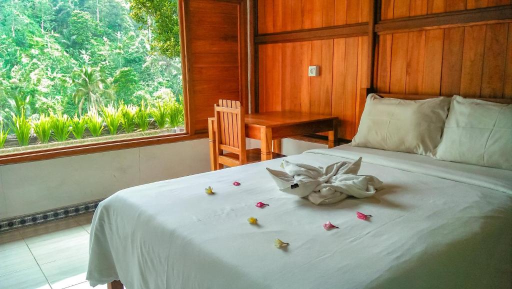 布莱伦Buda's Homestay Lemukih的一间卧室,配有一张带鲜花的床