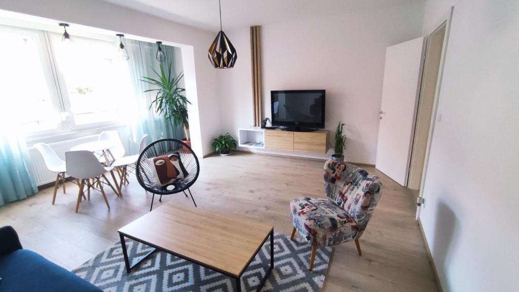 图兹拉Apartman Lena的客厅配有桌椅和电视。