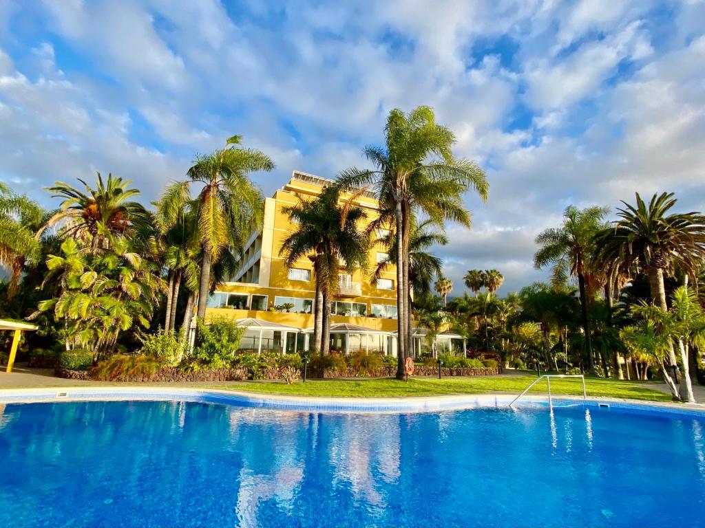 拉克鲁斯Hotel Tigaiga的一个带大型游泳池和棕榈树的度假村