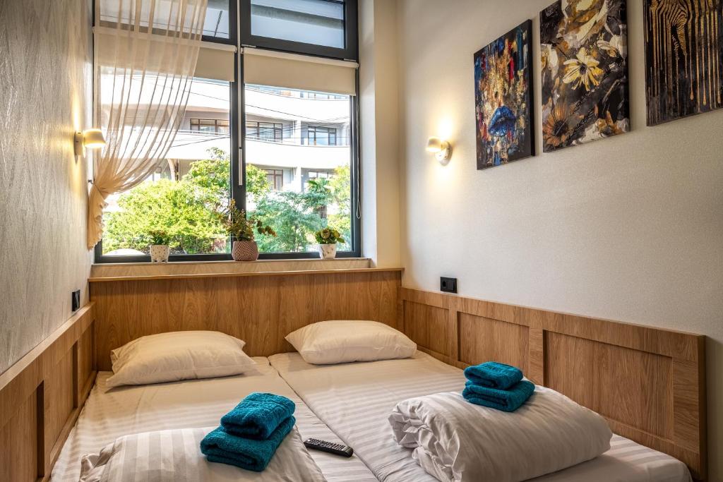 索契HiLoft Hostel的两张位于房间的床,上面有两条蓝色的毛巾