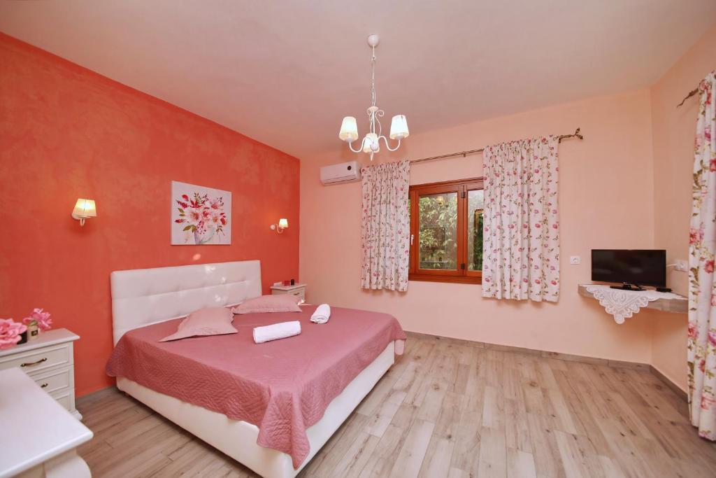 尼欧克利马Koromilia Villa的一间卧室设有一张床、一台电视和一个窗口。