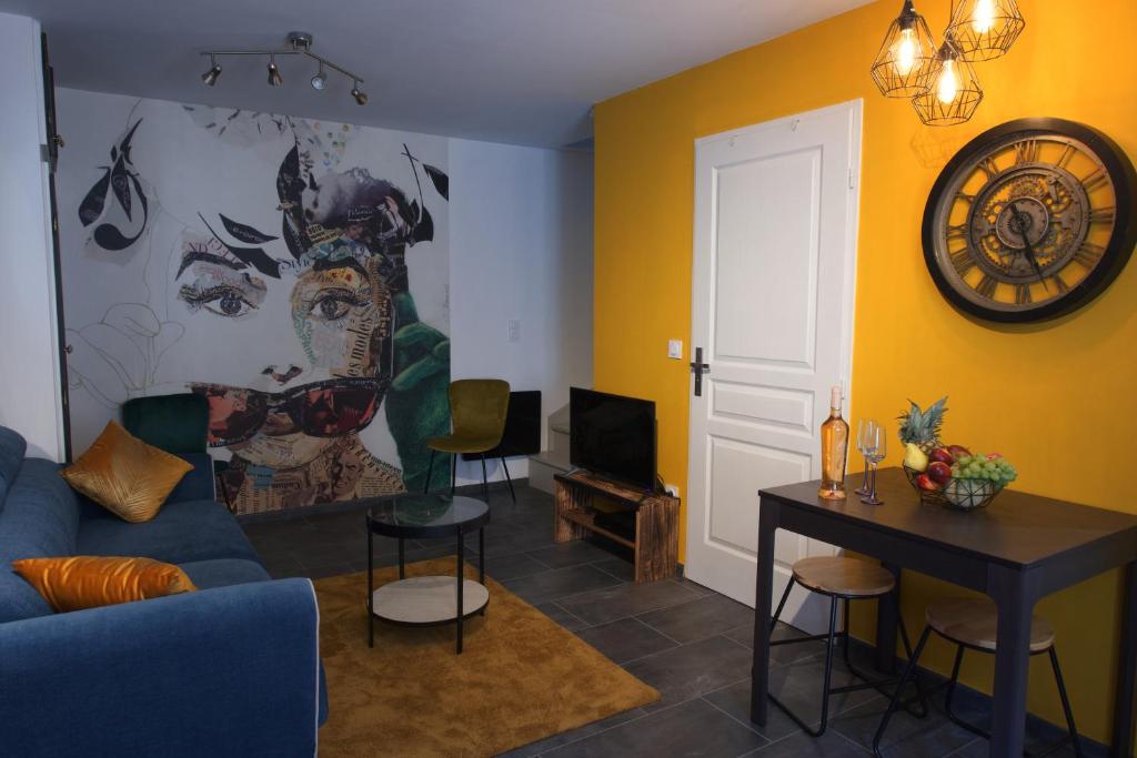 多勒Duplex charmant idéalement situé的客厅配有蓝色的沙发和墙上的绘画