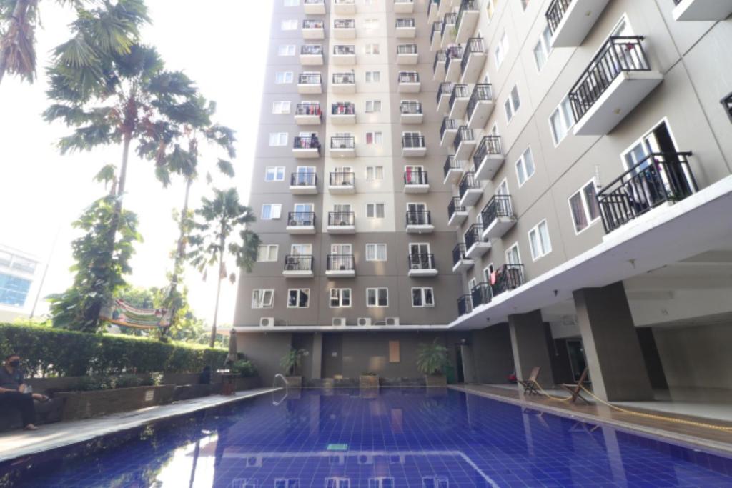 雅加达桑特公园景阿达鲁公寓的大楼前设有游泳池的酒店