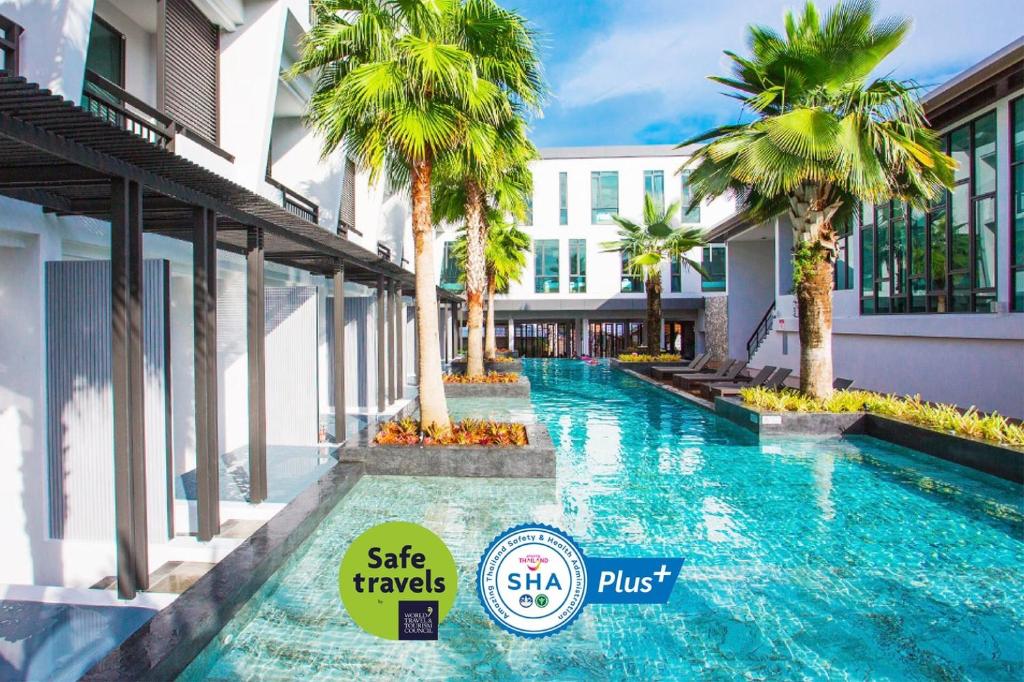 查汶Chaweng Villawee Hotel - SHA Plus的一座楼前棕榈树游泳池