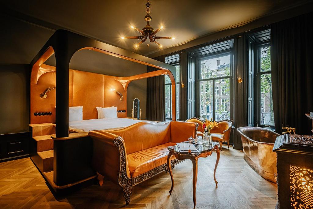 阿姆斯特丹Boutique Hotel The Noblemen的酒店客房配有床、沙发和桌子。
