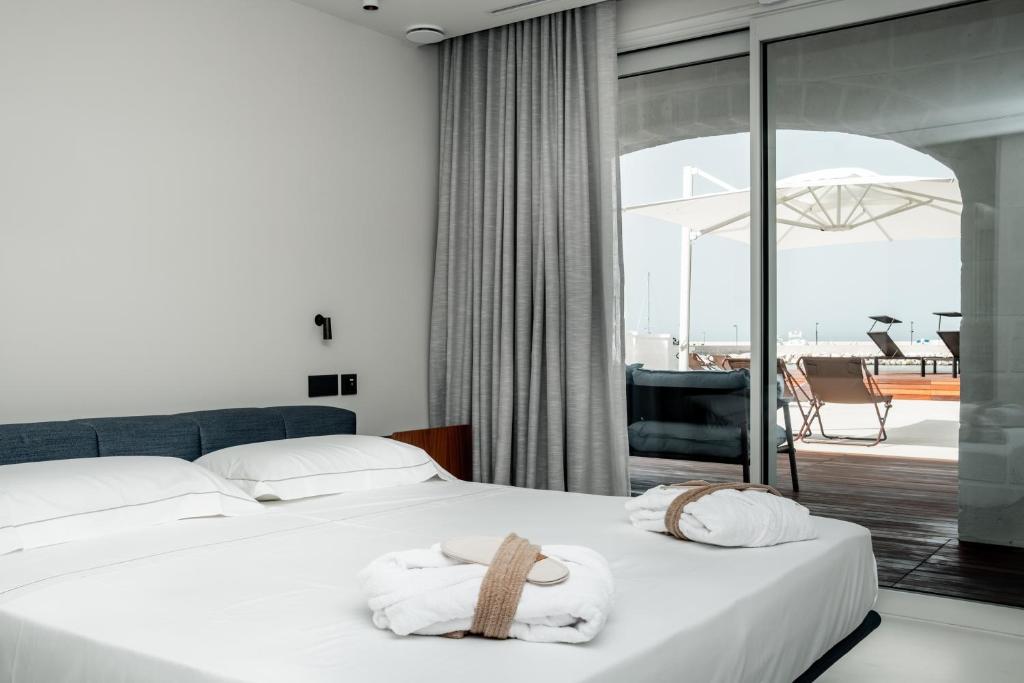 滨海波利尼亚诺Le 3 di Tuccino的酒店客房,配有带毛巾的床