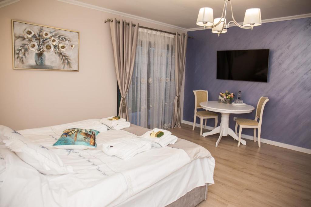 CoruşuSeara pe deal的卧室配有一张白色的大床和一张桌子