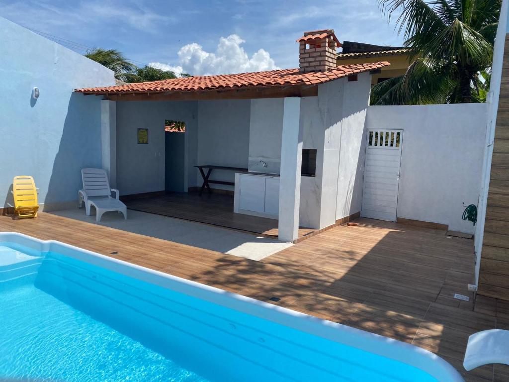 阿拉卡茹Casa Frida Aracaju a 500m da praia的别墅毗邻一座房子,设有游泳池