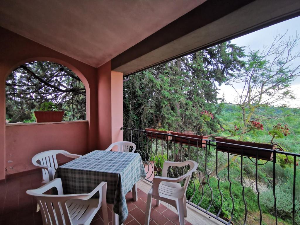 萨杜勒尼亚Il Melograno Country House的阳台配有桌椅和窗户。