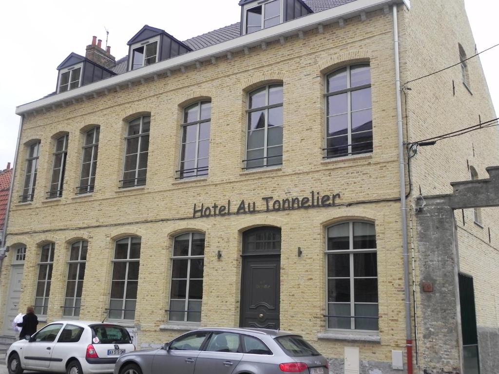 贝尔格Hôtel - Restaurant Au Tonnelier的两辆汽车停在砖楼前