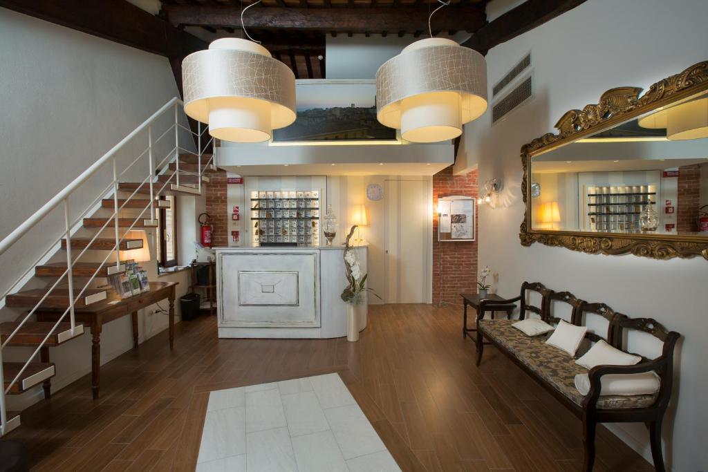 锡耶纳阿尔玛多莫斯酒店的一间带楼梯和镜子的客厅