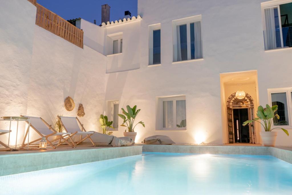 赫雷斯-德拉弗龙特拉Suites Alfonso X的一座带游泳池和房子的别墅