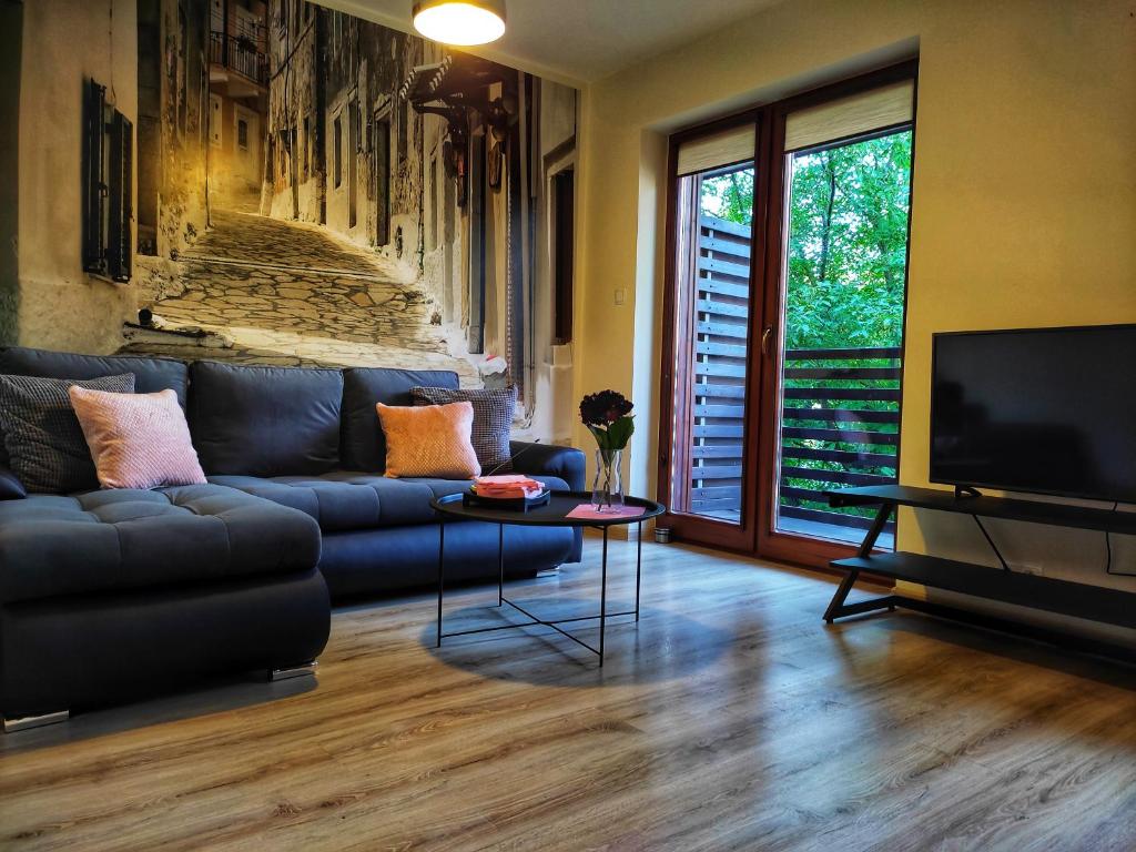 绿山城SleepWell的客厅配有蓝色的沙发和电视