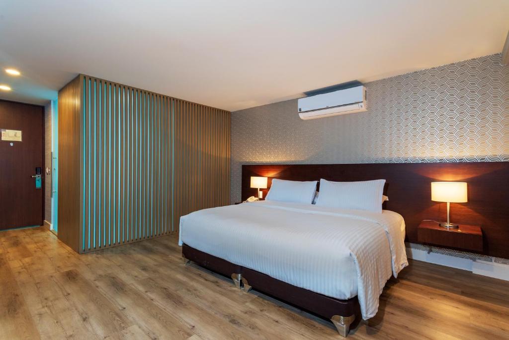 波哥大圣巴巴拉精品酒店的卧室配有一张白色大床和两盏灯。