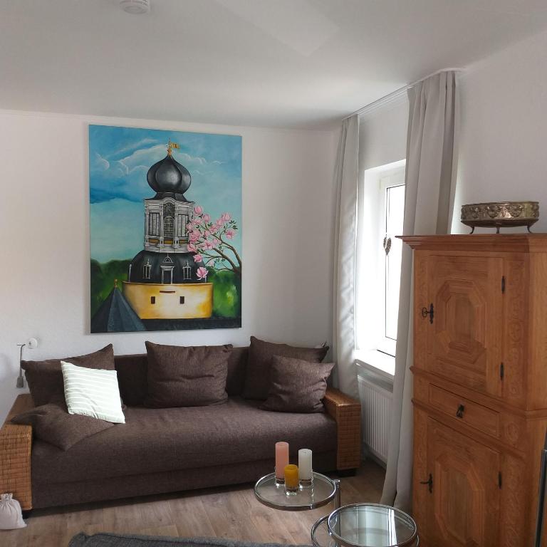 耶弗尔Friesenauster - große Ferienwohnung für bis zu 6 Personen的客厅配有沙发和墙上的绘画