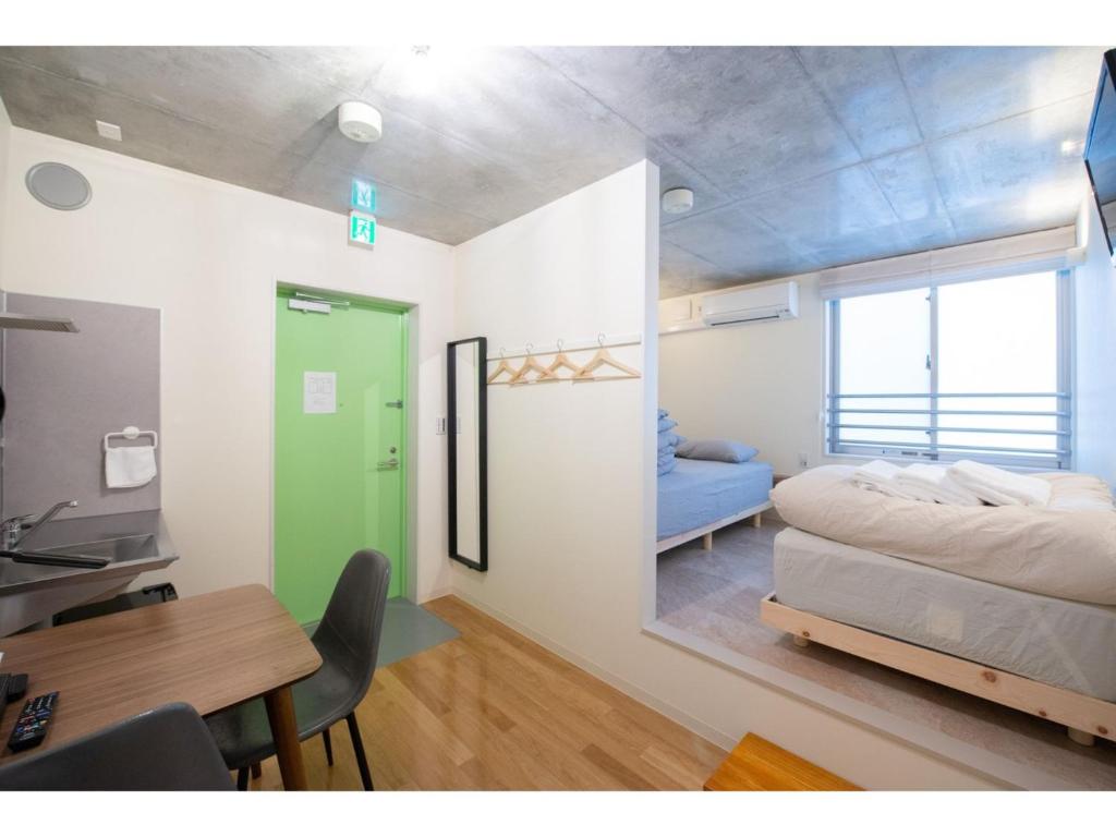 东京bmj Hyakunincho - Vacation STAY 68273v的一间卧室配有一张床、一张桌子和一张桌子