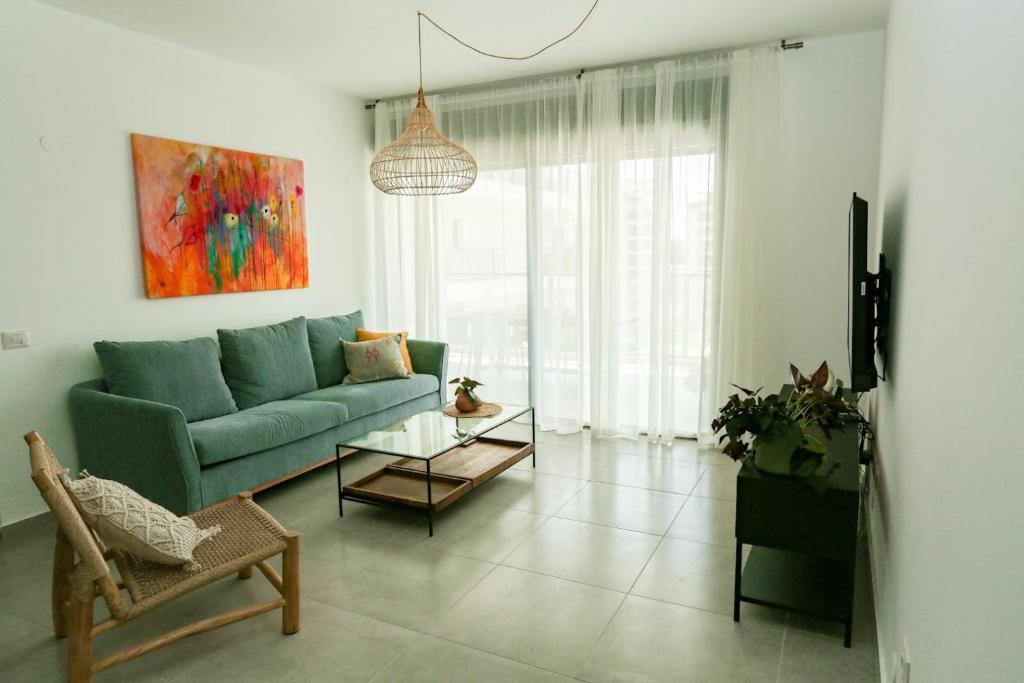纳哈里亚פנינה באכזיב- מול הים- achzivacation的客厅配有蓝色的沙发和桌子