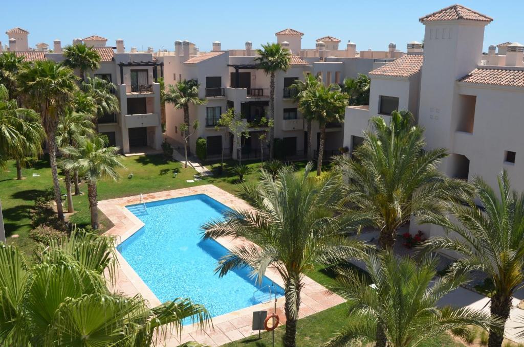 Roda度假胜地之选罗达高尔夫5508度假公寓的享有公寓大楼的空中景致,设有游泳池和棕榈树