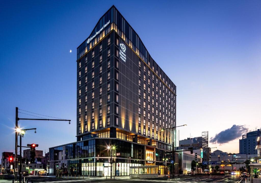 山形市Daiwa Roynet Hotel Yamagata Ekimae的一座高大的建筑,旁边有一个标志