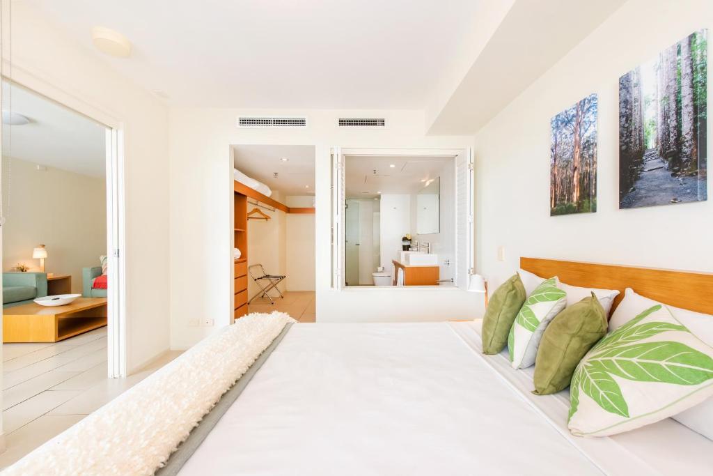 麦凯拉奈河滨公寓 的一间白色的卧室,配有一张大床和一个客厅