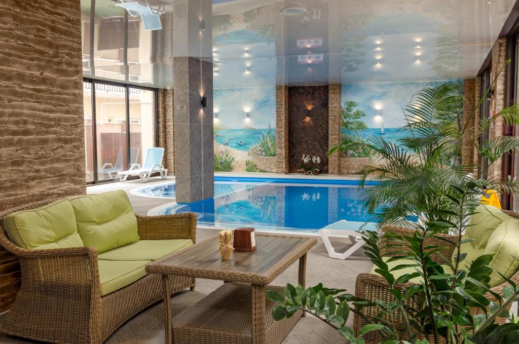 格连吉克Hotel Orion的客厅设有游泳池、桌子和椅子