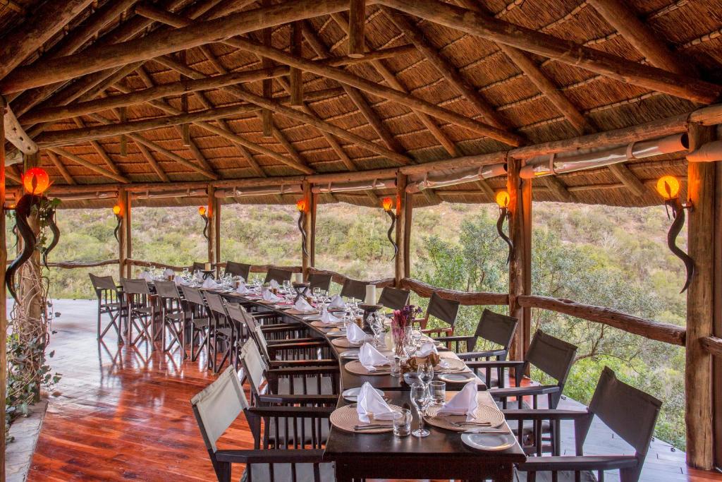 帕特森Lalibela Game Reserve Lentaba Safari Lodge的长长的用餐室配有长桌子和椅子