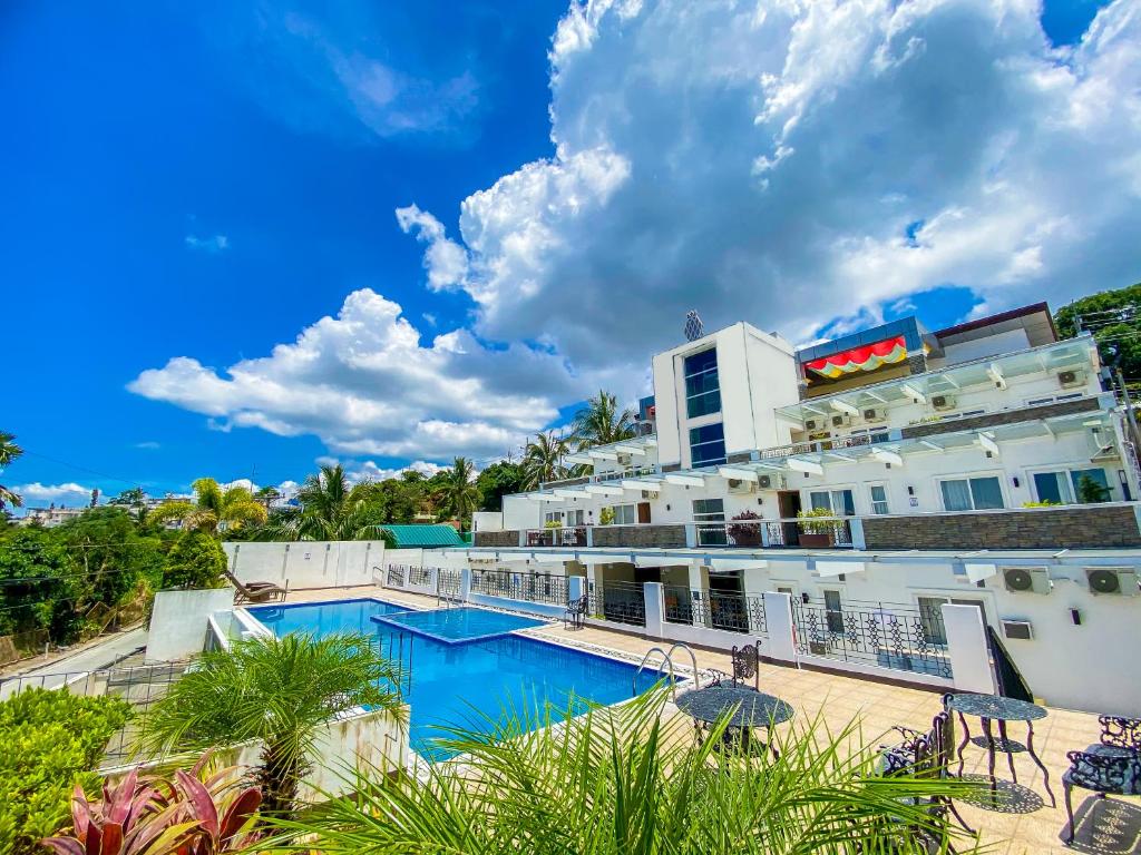 大雅台Tagaytay Hotel SixB的大楼前设有游泳池的酒店