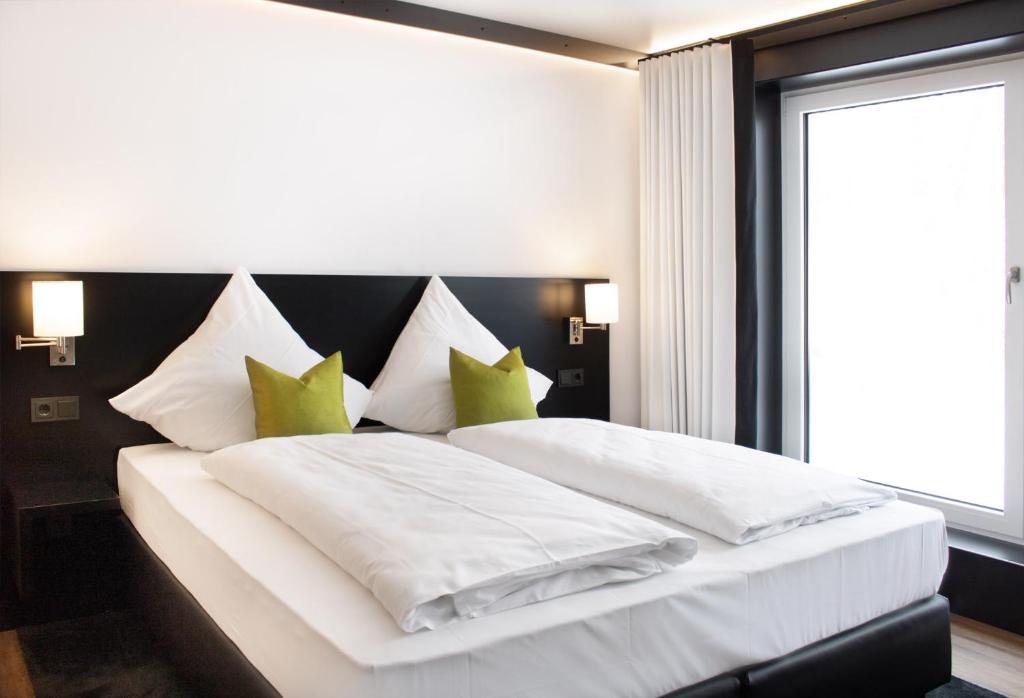 格尔利茨GR Hotel by WMM Hotels的卧室配有带绿色枕头的大型白色床