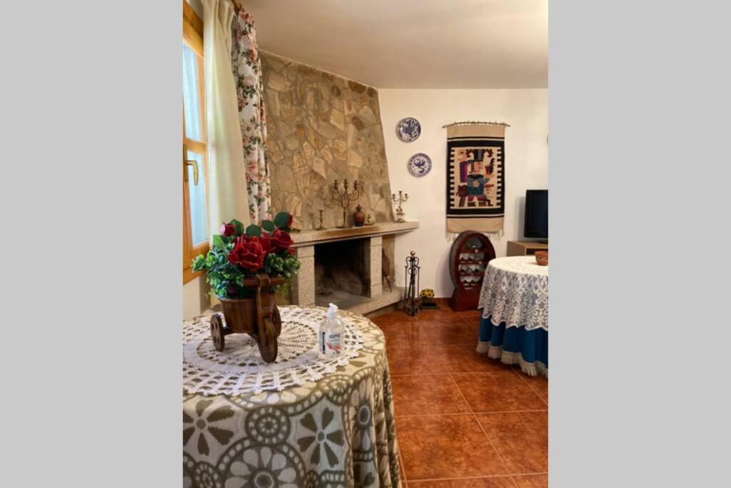 SampilCasa rural: Villa Marías的客厅配有桌子和壁炉