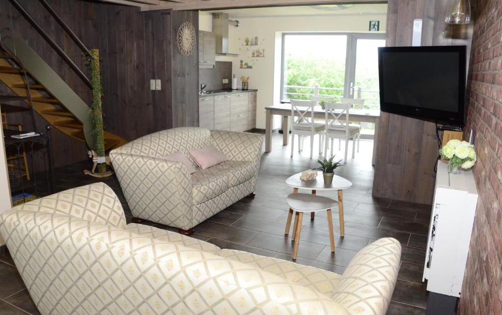 塞尔方丹Gîtes Paille-Foin的客厅配有沙发、椅子和电视