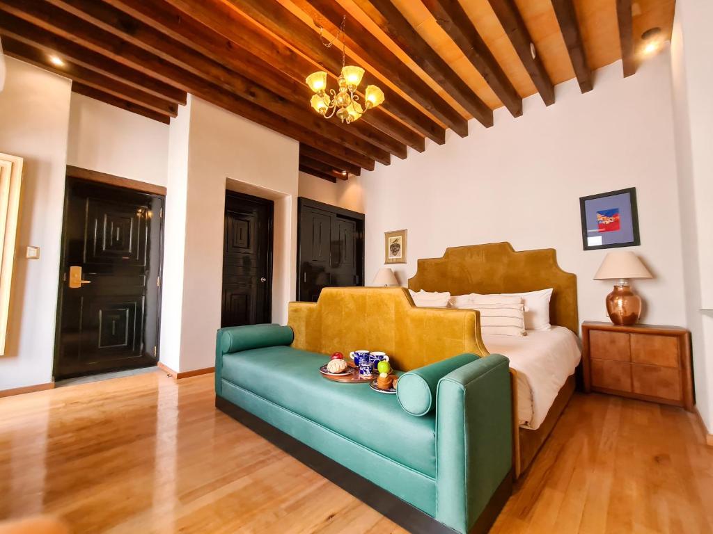 瓜纳华托Casona Alonso 10- Hotelito Mexicano的一间卧室配有一张床和一张蓝色的沙发