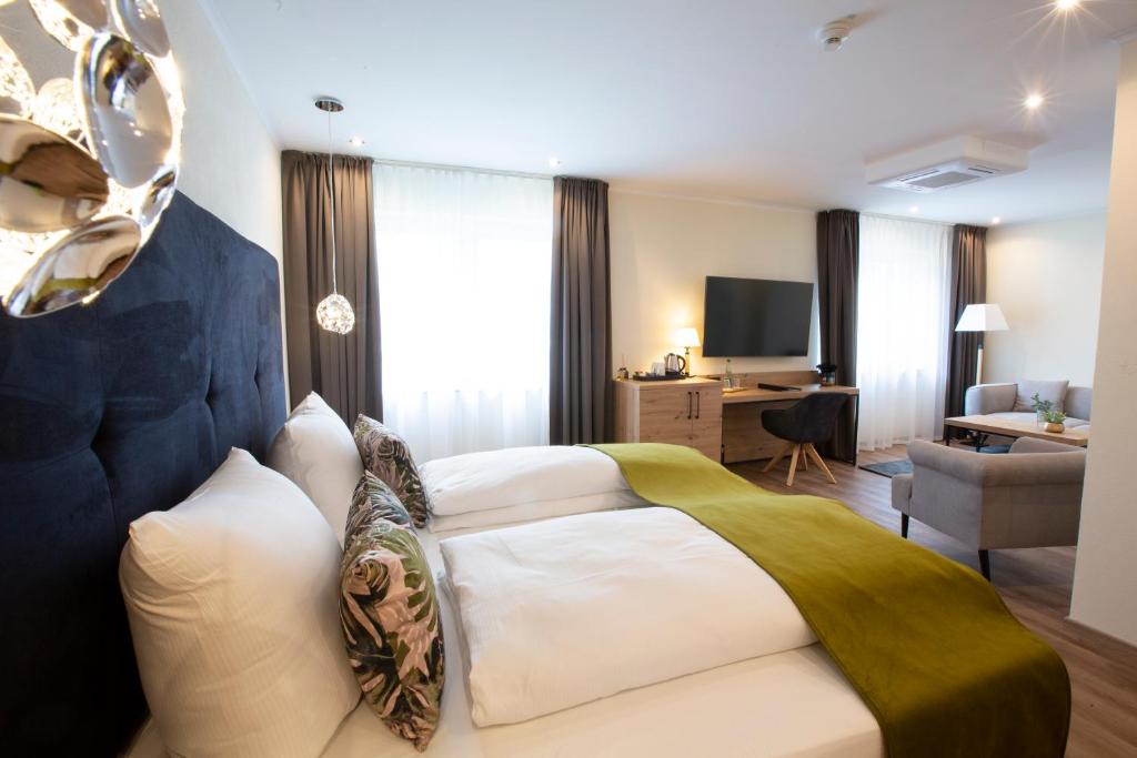 利希滕费尔斯Stadthotel Lichtenfels的配有一张床和一张书桌的酒店客房