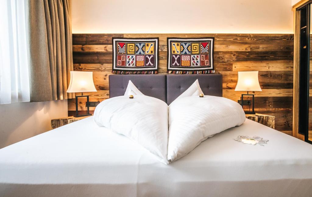 圣安东阿尔贝格Hotel Andino的卧室配有白色的床和2个枕头