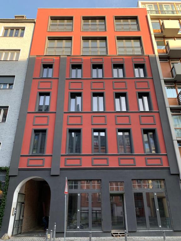 柏林Art Apartments的前面有拱门的红色建筑
