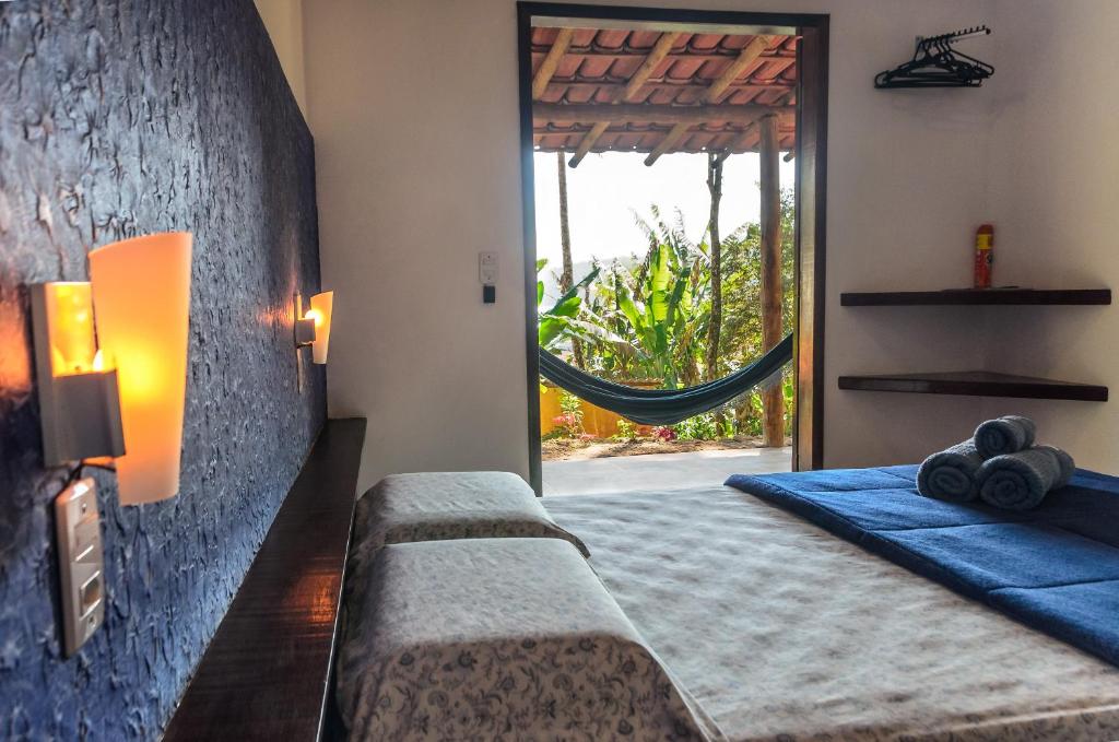 Praia do BananalFauna的一间卧室配有一张床,窗户配有吊床