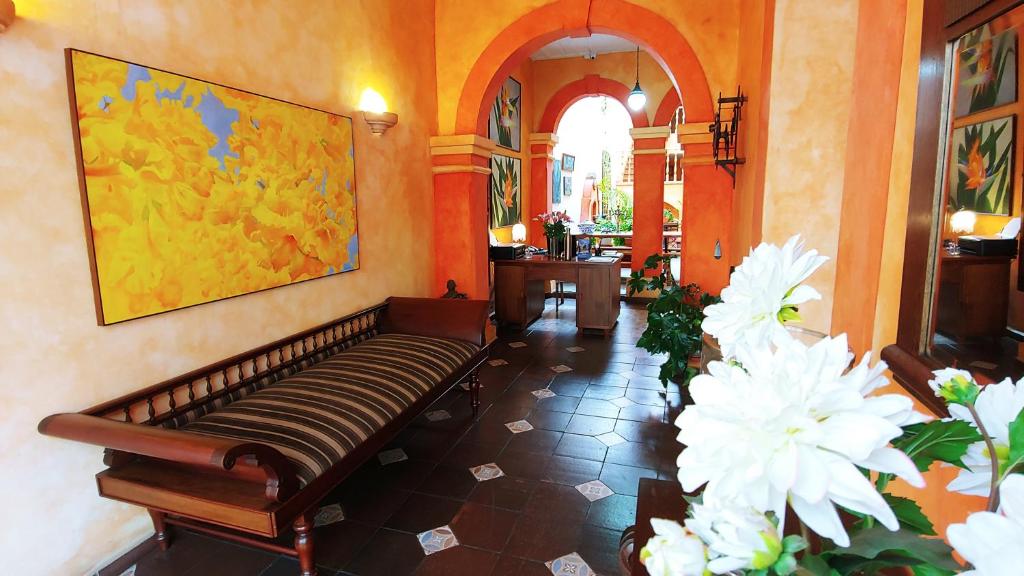 昆卡Casa Montalvo Bed & Breakfast的大楼内带长凳和鲜花的走廊