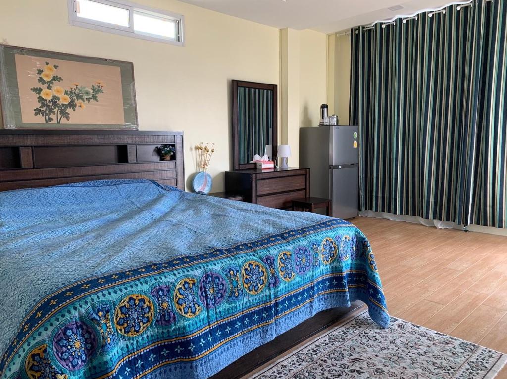 清迈Gumpuju คำปู้จู้的一间卧室配有一张带蓝色毯子的床