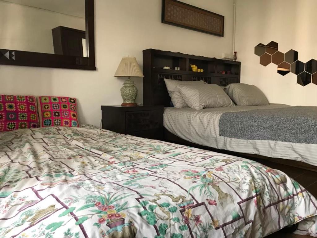 清迈Kiang Mo Gumpuju的一间卧室配有两张床和镜子