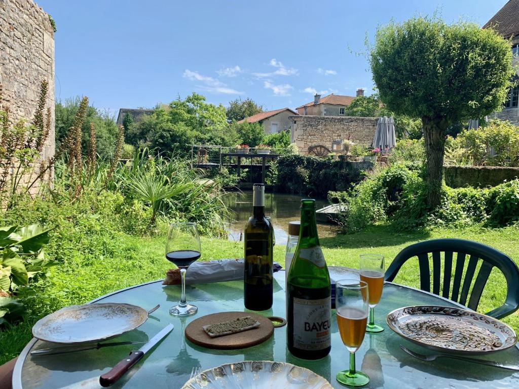 Verteuil-sur-CharenteRue des Douves的一张桌子,上面放有两瓶葡萄酒和眼镜