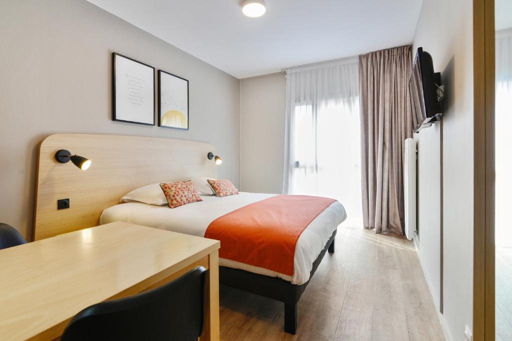 布鲁瓦Appart'City Classic Blois的配有一张床和一张书桌的酒店客房