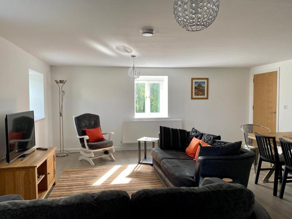阿尼克29 Malthouse Alnwick Holiday Apartment的带沙发和电视的客厅