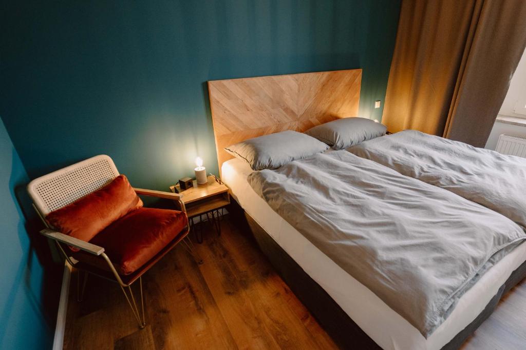希尔德斯海姆Schlafladen Hildesheim Hotel & Hostel的一间卧室配有一张大床和一把椅子