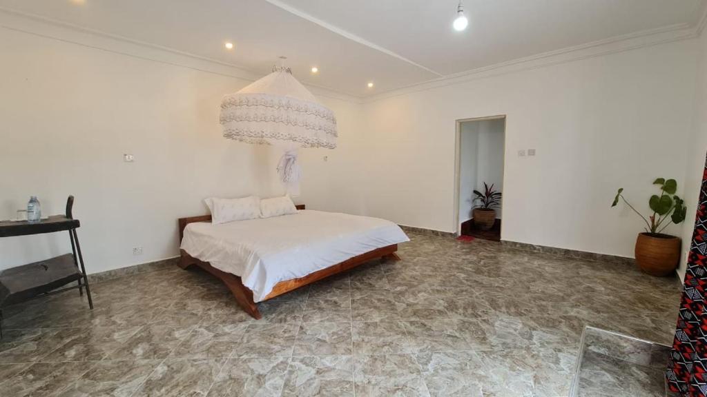 姆巴拉拉GKAT Resort的一间卧室配有一张床和一个吊灯